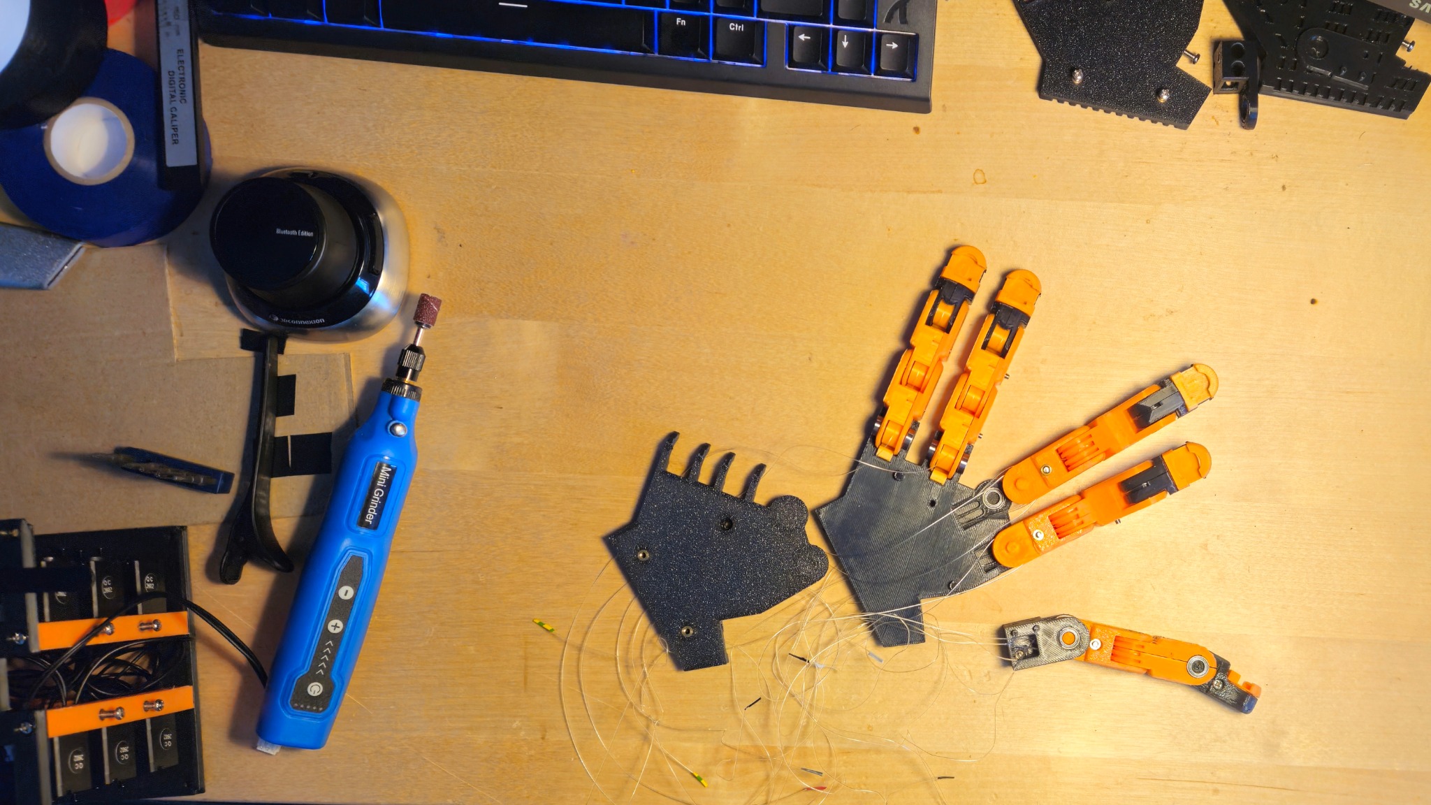 Top-down view of a tendon-driven robotic hand project on a workbench
